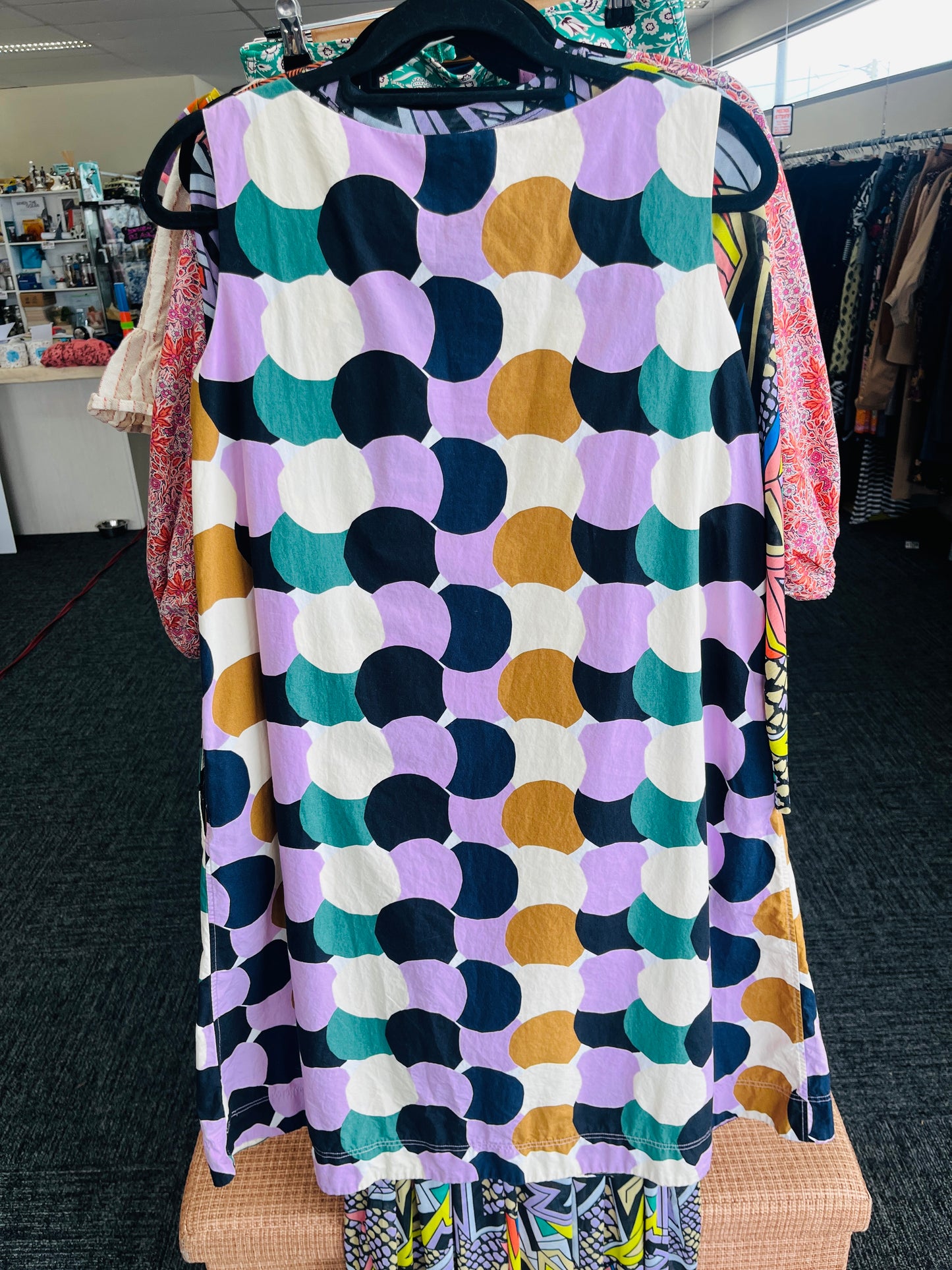 Colorful patterned dress hanging on a rack in a store