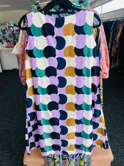Colorful patterned dress hanging on a rack in a store