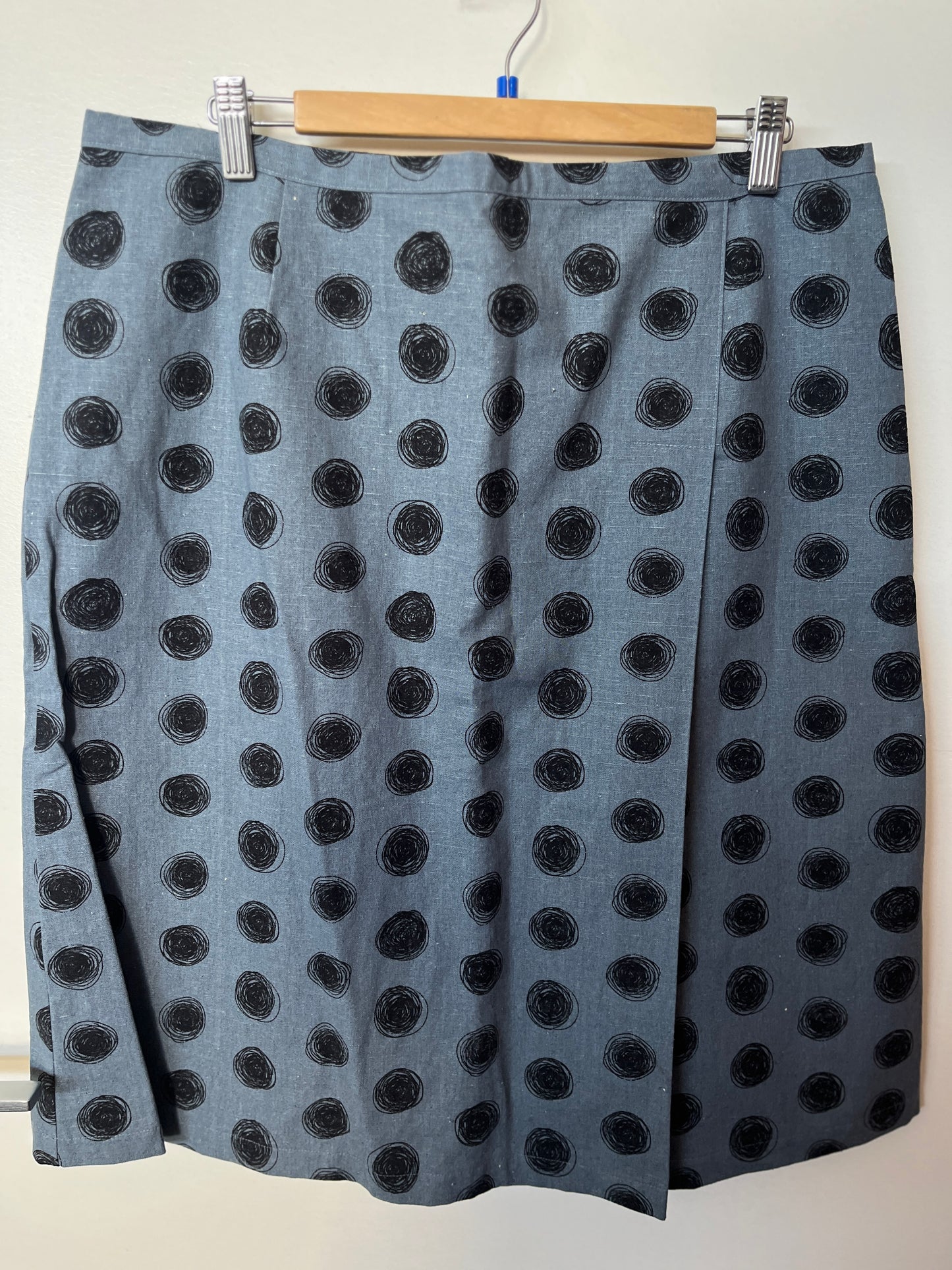 Gray skirt with black polka dots on a hanger