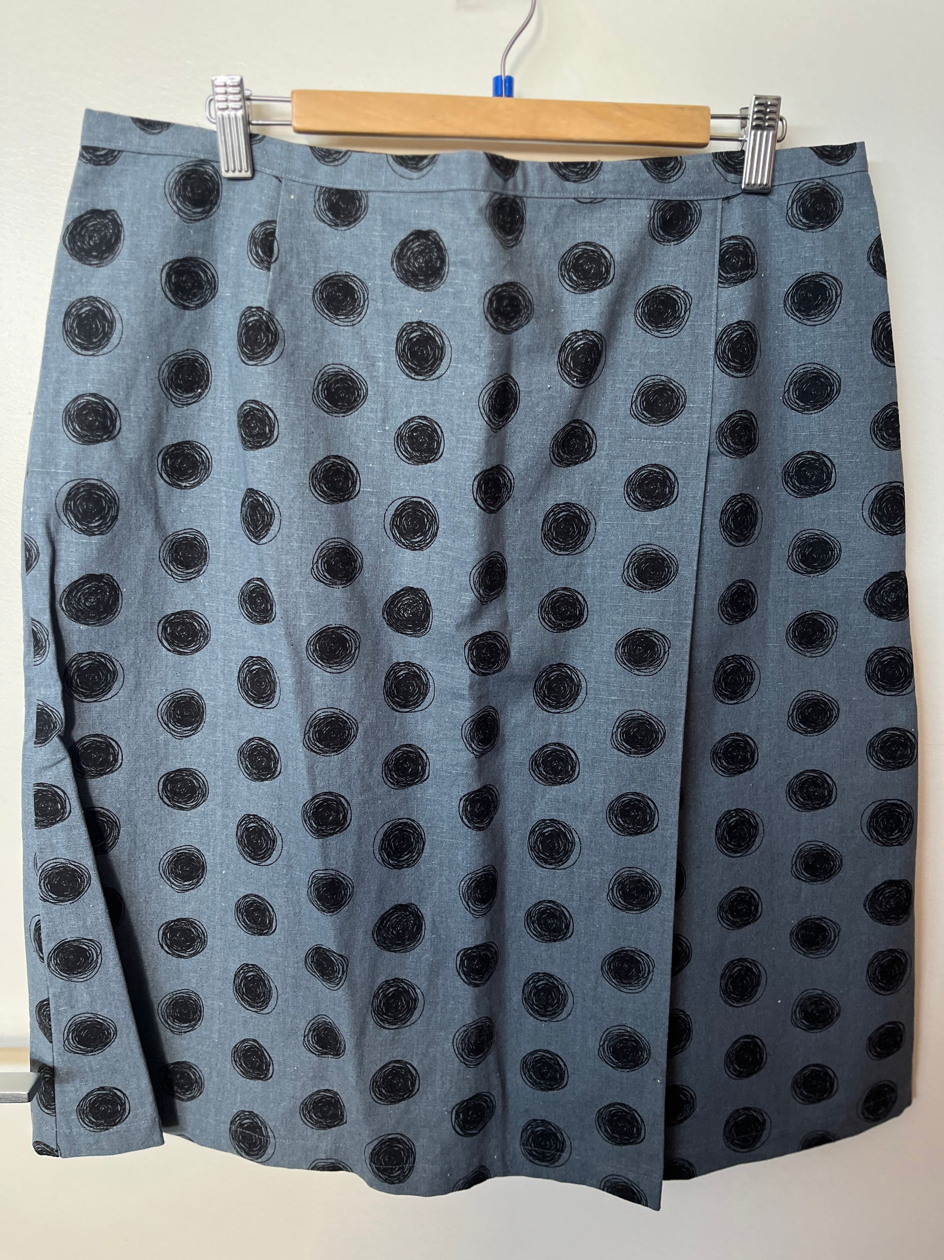 Gray skirt with black polka dots on a hanger