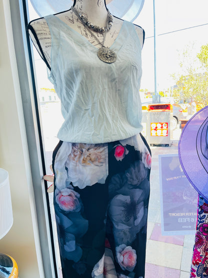 Mannequin wearing a light-colored top and dark floral pants
