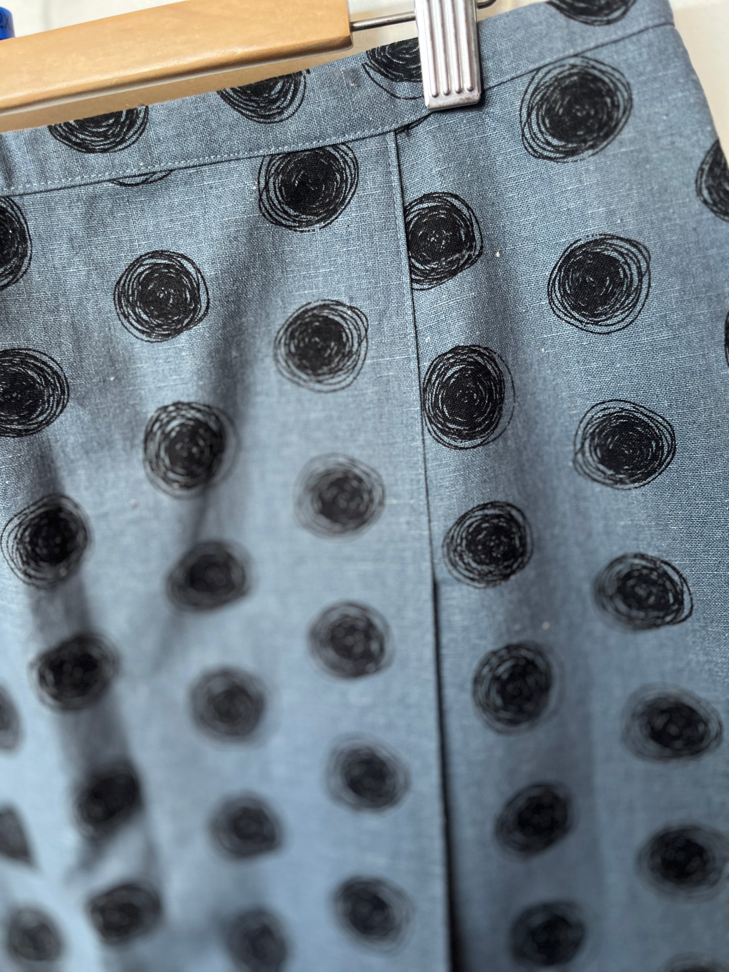 Gray fabric with black circular patterns on a hanger