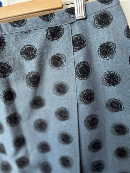 Gray fabric with black circular patterns on a hanger