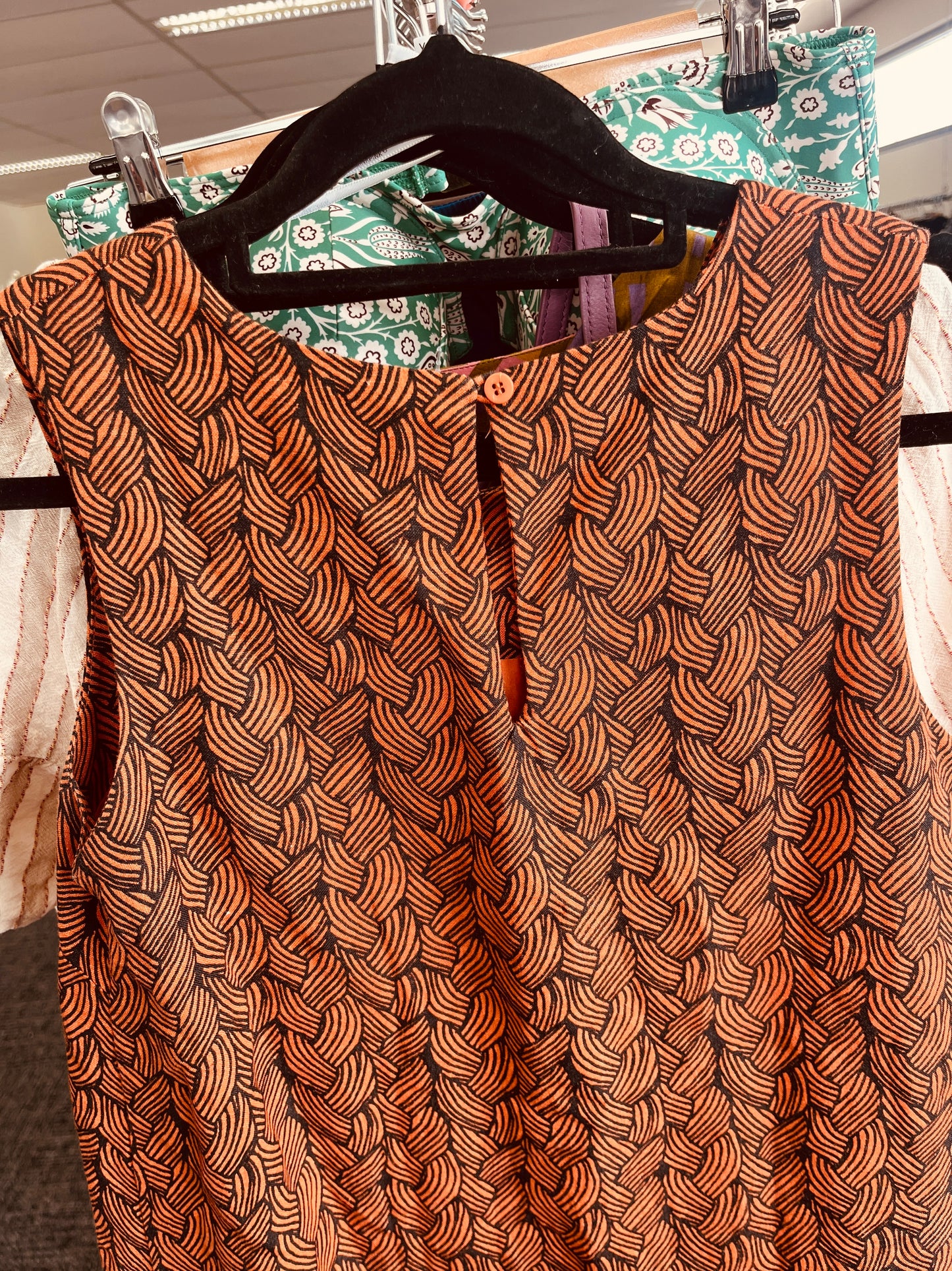 Brown patterned top on a hanger
