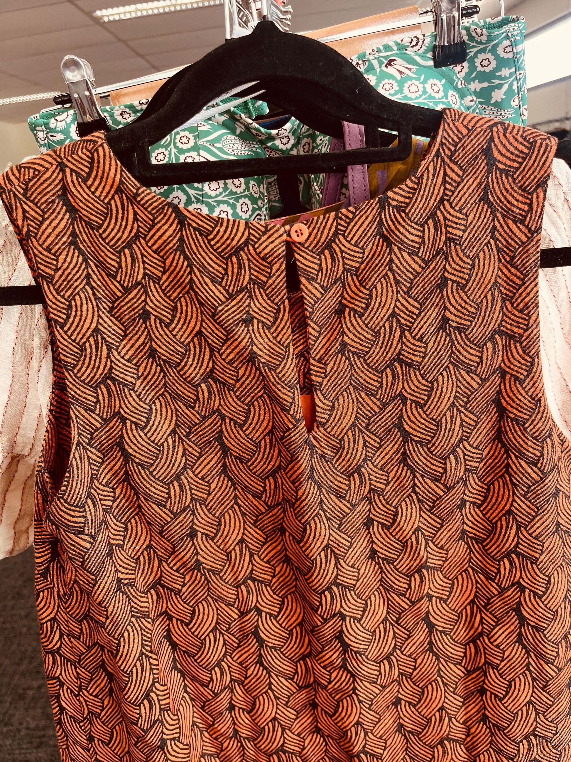 Brown patterned top on a hanger