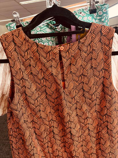 Brown patterned top on a hanger
