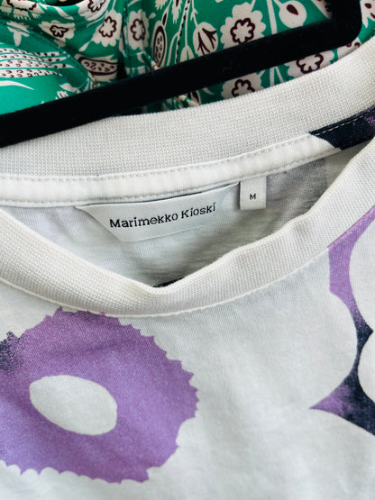 Close-up of a garment with floral patterns and 'Marimekko Kioski' label.