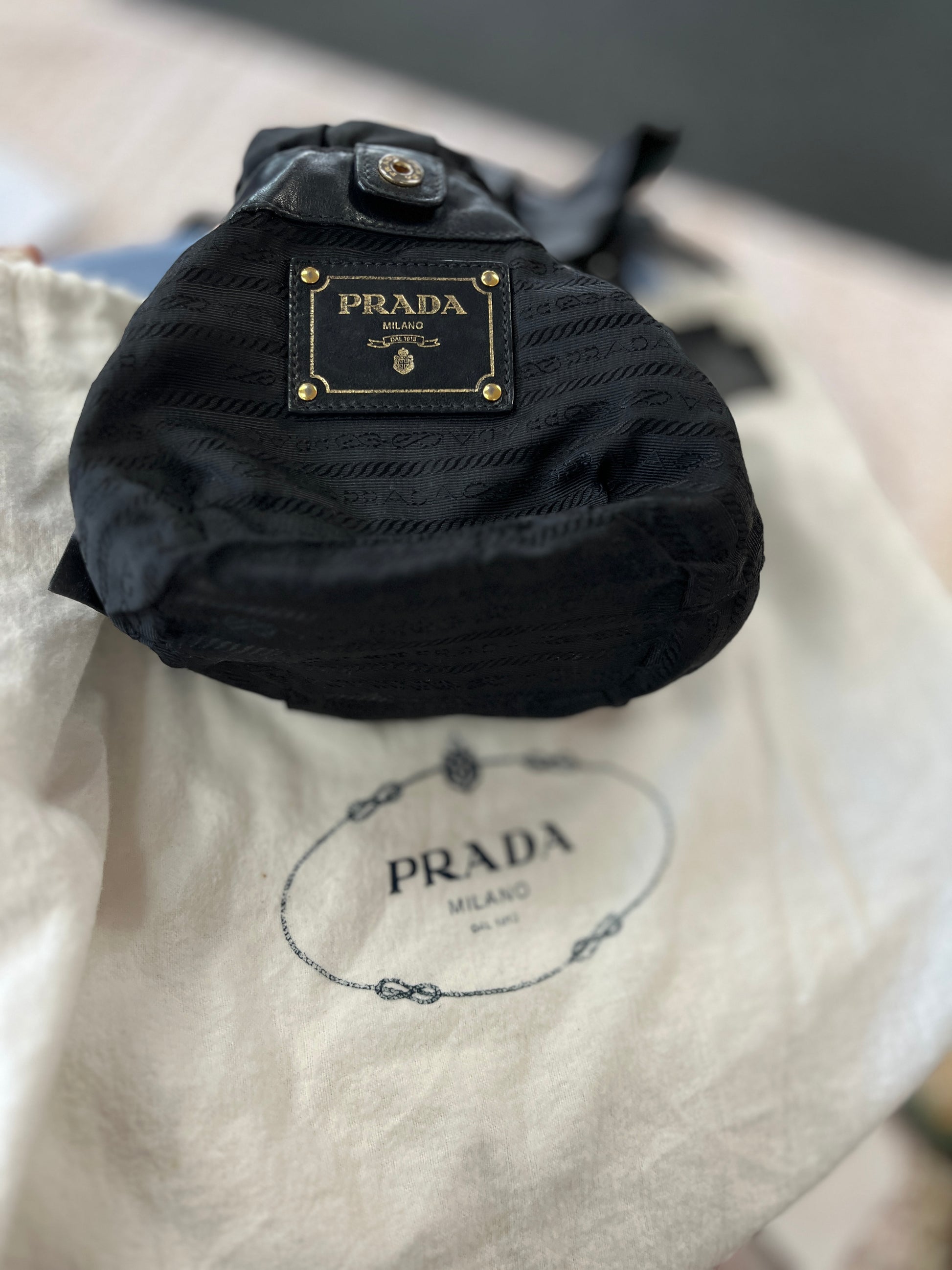 Black Prada bag on a beige Prada dust bag