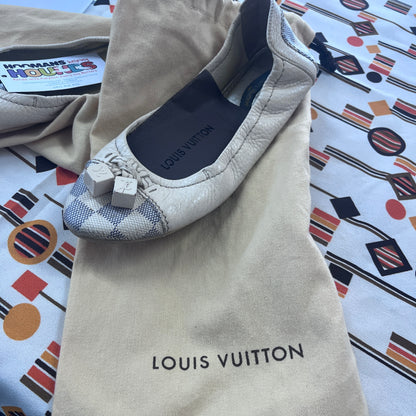 Louis Vuitton flat shoe on a branded pouch with a colorful patterned background