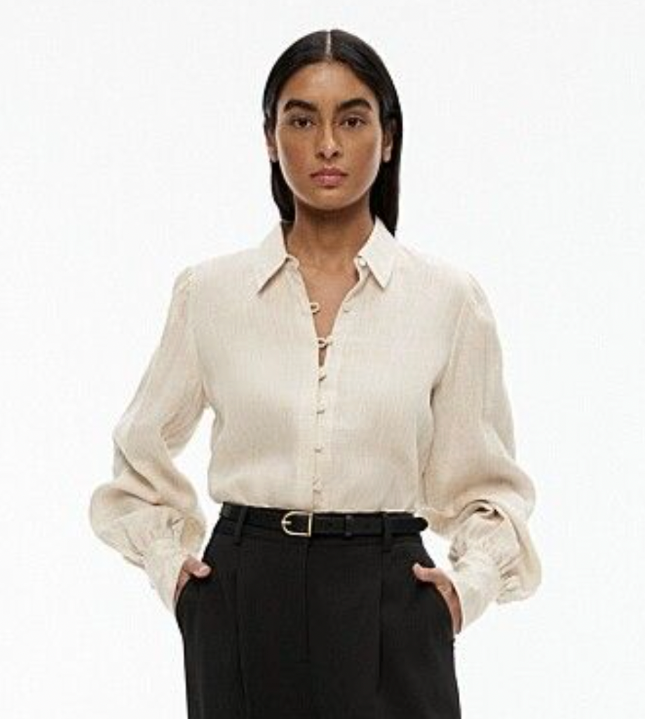 Woman wearing a light-colored shirt and dark pants